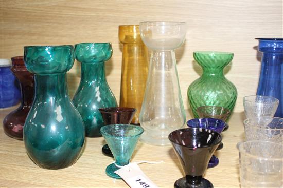 Seven Edwardian coloured glass hyacinth vases, a slender specimen vase and a thirteen other assorted glasses